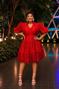Red puff sleeve eyelet lace skater dress styled with white strappy heels in evening setting