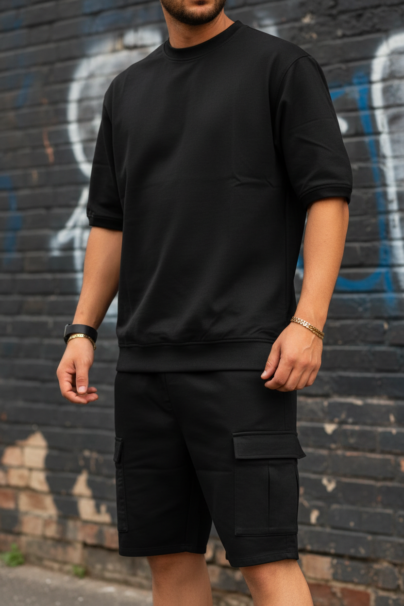 Man wearing black oversized tee and cargo shorts matching set