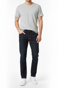 Man wearing dark navy straight leg jeans with white sneakers